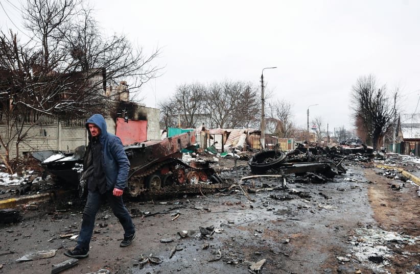  A MAN walks past destroyed military vehicles in the Kyiv region on March 1. (photo credit: Serhii Nuzhnenko/Reuters)