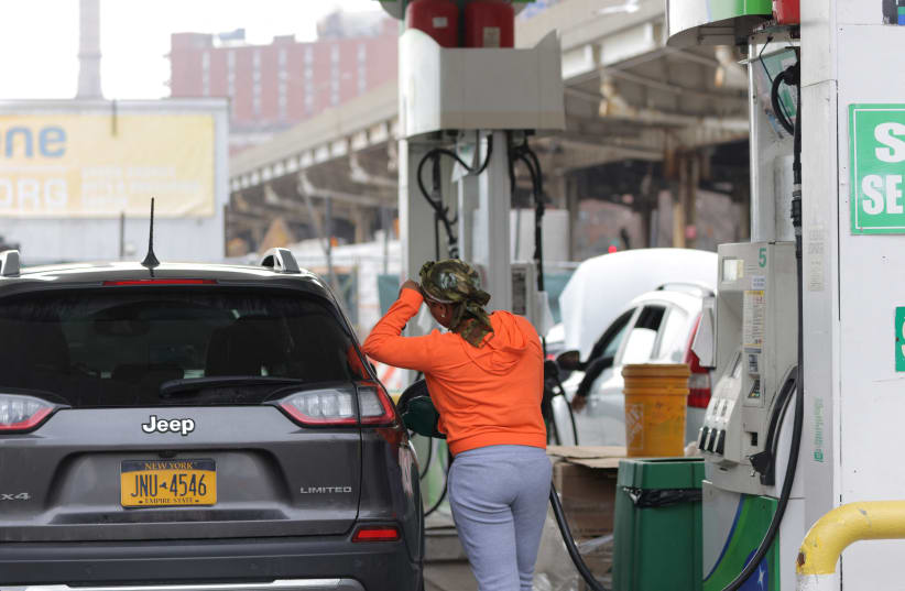  A person uses a petrol pump at a gas station as fuel prices surged in Manhattan, New York City, US, March 7, 2022.  (photo credit: REUTERS/ANDREW KELLY)