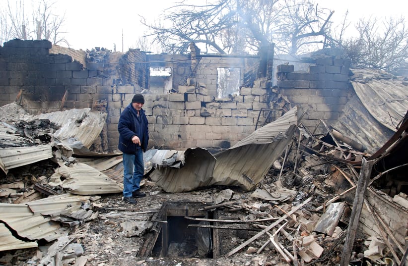  A man stands on the rubble of a house destroyed by recent shelling during Ukraine-Russia conflict in Kharkiv, Ukraine March 7, 2022. (photo credit: Oleksandr Lapshyn/Reuters)