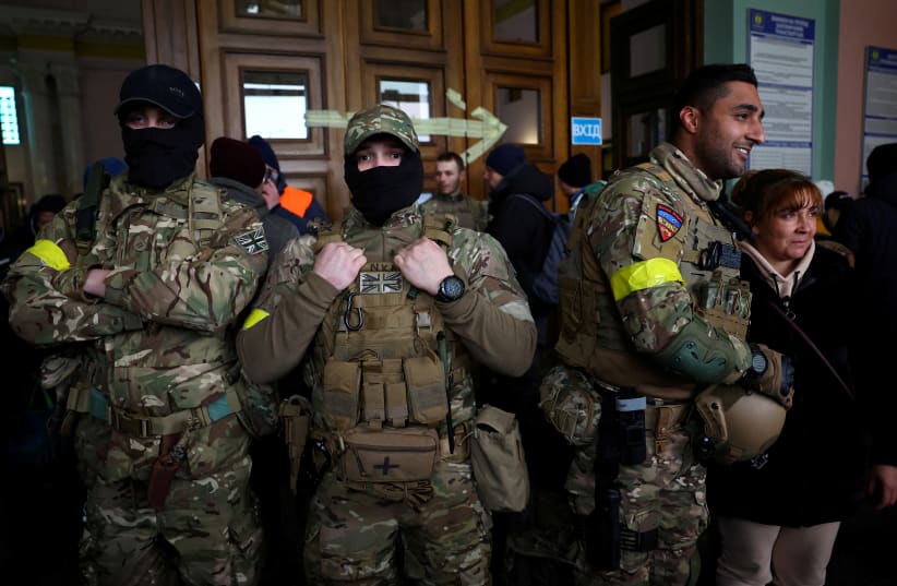  Ben Grant and other foreign fighters from the UK pose for a picture as they are ready to depart towards the front line in the east of Ukraine following the Russian invasion, at the main train station in Lviv, Ukraine, March 5, 2022. (photo credit: KAI PFAFFENBACH/REUTERS)