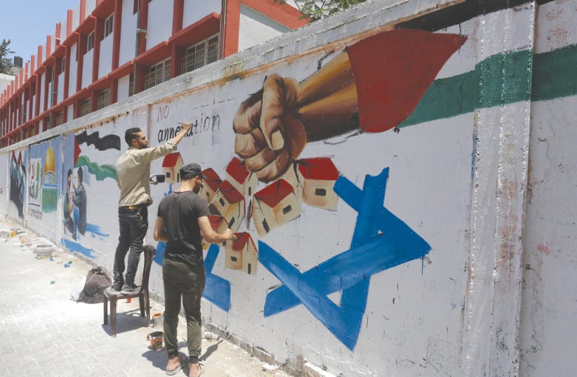  A PALESTINIAN artist draws a mural in Rafah, Gaza Strip, against Israel’s West Bank annexation plans, in 2020. (photo credit: ABED RAHIM KHATIB/FLASH90)