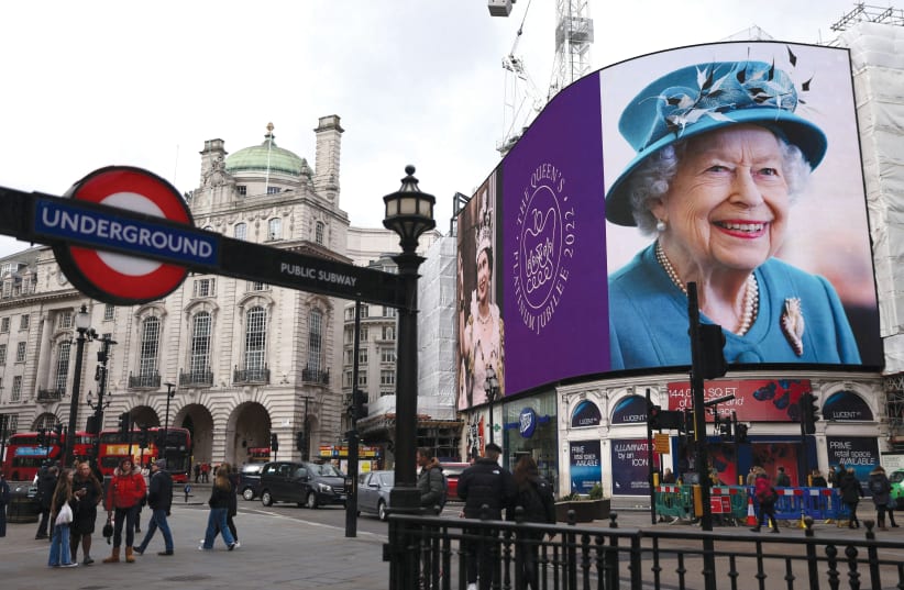  A screen in Piccadilly Circus shows a photograph of Britain’s Queen Elizabeth along with the Platinum Jubilee emblem to celebrate the 70th anniversary of the monarch’s accession to the throne in London, on February 6, 2022.  (photo credit: REUTERS/TOM NICHOLSON)