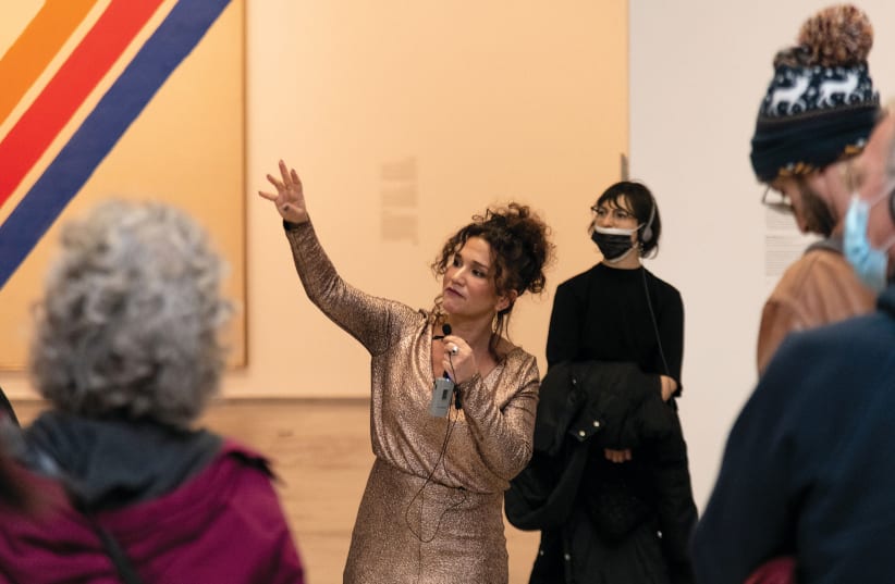  CURATOR ADINA KAMIEN gets animated next to a large painting by Kenneth Noland. (photo credit: ELIE POSNER)