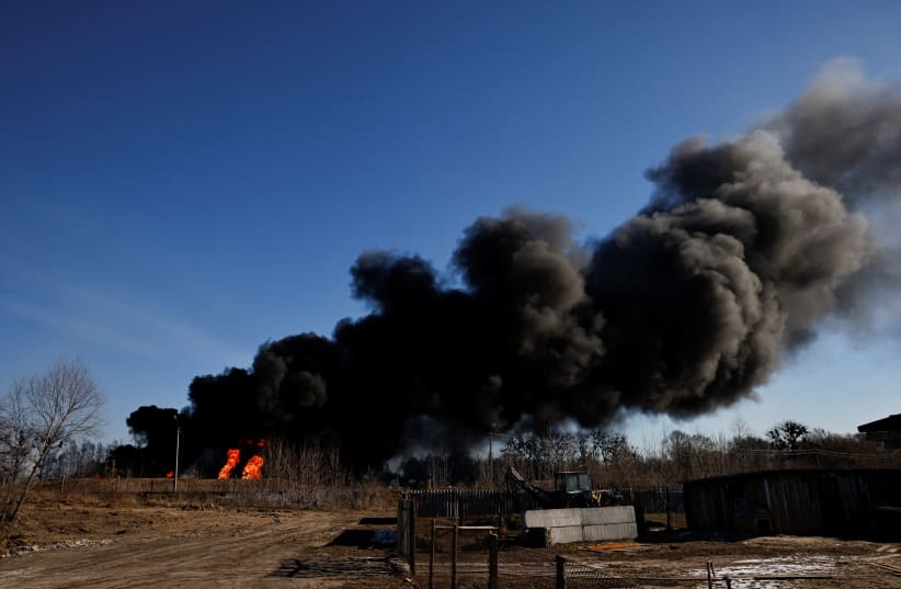  A column of smoke rises from burning fuel tanks that locals said were hit by five rockets at the Vasylkiv Air Base, following Russia's invasion of Ukraine, outside Kyiv, Ukraine, March 12, 2022.  (photo credit: THOMAS PETER/REUTERS)