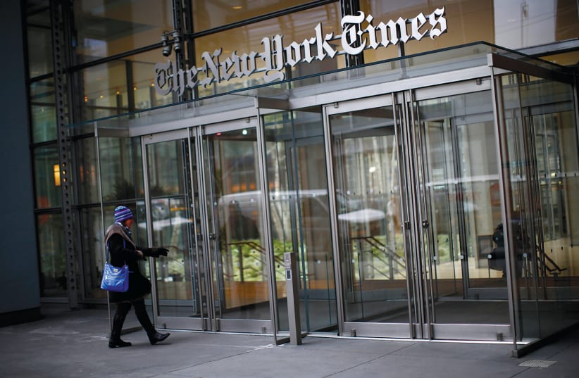  A WOMAN enters the ‘New York Times’ building in Manhattan. Almost everything related to threats or attacks against Israel is simply not reported. (photo credit: ERIC THAYER/REUTERS)