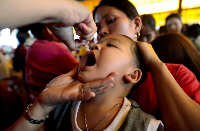  A child receives free polio vaccine during a government-led mass vaccination program in Quezon City, Metro Manila, Philippines, October 14, 2019. (photo credit: ELOISA LOPEZ/ REUTERS)