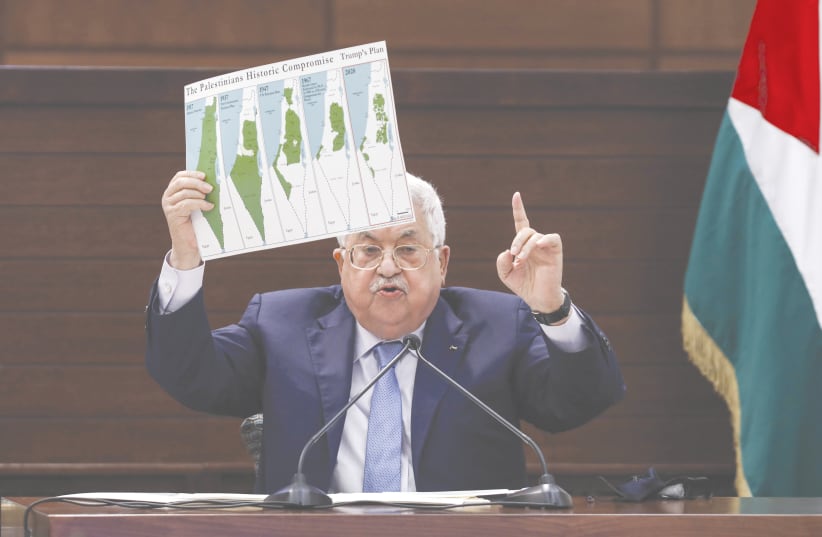 PA PRESIDENT Mahmoud Abbas holds a placard showing maps of (from left) historical Palestine, the 1937 Peel Commission partition plan, the 1947 United Nations partition plan on Palestine, the 1948-1967 borders between the Palestinian territories and Israel, and a map of US president Donald Trump’s p (photo credit: Alaa Badarneh/pool/AFP via Getty Images)