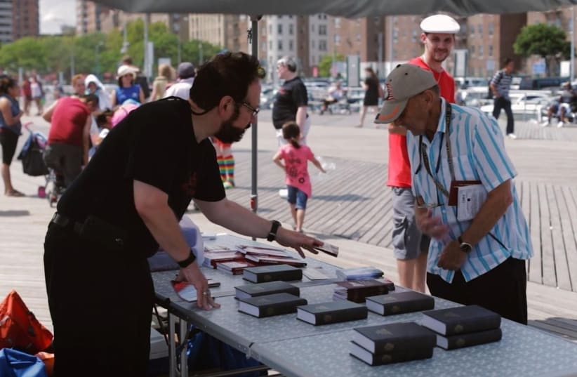  A member of Chosen People Ministries hands out bibles in New York City. (photo credit: YOUTUBE)