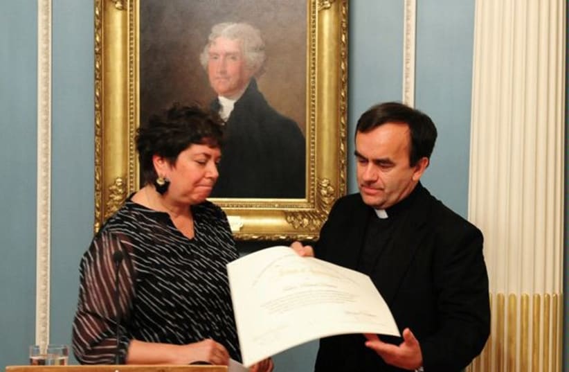 On Thursday, May 12, 2011, Special Envoy to Monitor and Combat Anti-Semitism Hannah Rosenthal recognized the work of Father Patrick Desbois, President of the Yahad-In Unum Association of France, with a Tribute of Appreciation certificate. (photo credit: US DEPARTMENT OF STATE/PHOTOGRAPHER NOT SPECIFIED/PUBLIC DOMAIN/VIA WIKIMEDIA COMMONS)