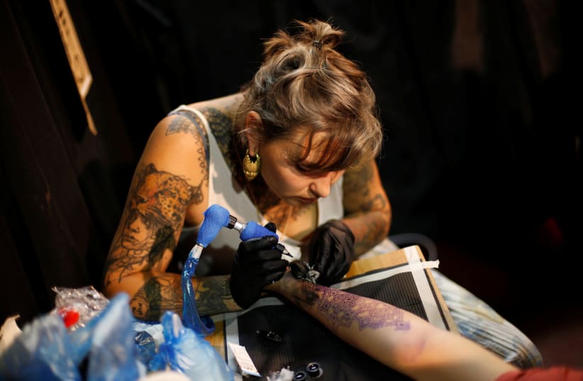  A tattoo artist at work during the annual Israel Tattoo Convention in Tel Aviv. (photo credit: BAZ RATNER/REUTERS)