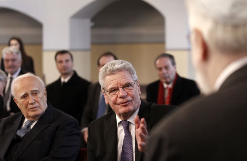  GERMAN THEN-PRESIDENT Joachim Gauck (C) speaks to the head of the Greek-Jewish community of Ioannina during his 2014 visit to their synagogue in northwestern Greece, as tribute to the dozens massacred by the Nazis.  (photo credit: Alkis Konstantinidis/Reuters)