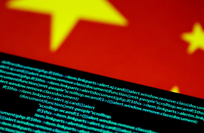  Computer code is seen on a screen above a Chinese flag in this illustration (photo credit: REUTERS/THOMAS WHITE/ILLUSTRATION)