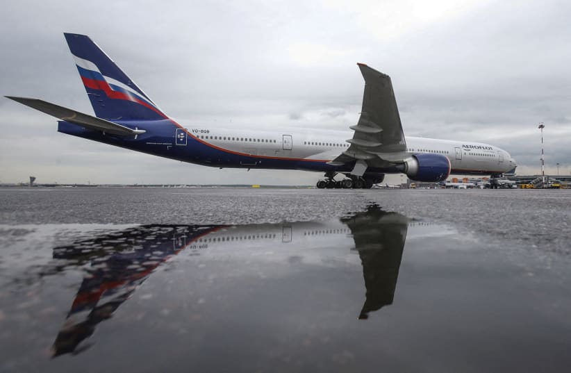  An Aeroflot Boeing 777-300ER aircraft is reflected in a puddle at Sheremetyevo International Airport outside Moscow, Russia, July 7, 2015. (photo credit: REUTERS/Maxim Shemetov/File Photo)