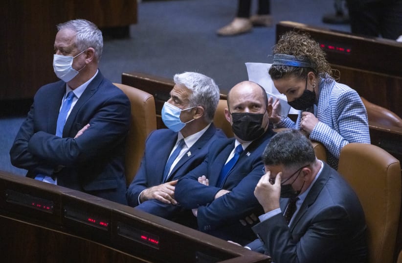  Israeli Defense Minister Benny Gantz, Israeli Foreign Minister Yair Lapid with Prime Minister Naftali Bennet and Idit Silman attend a plenary session at the assembly of the Knesset, the Israeli Parliament in Jerusalem, June 28, 2021 (photo credit: OLIVIER FITOUSSI/FLASH90)