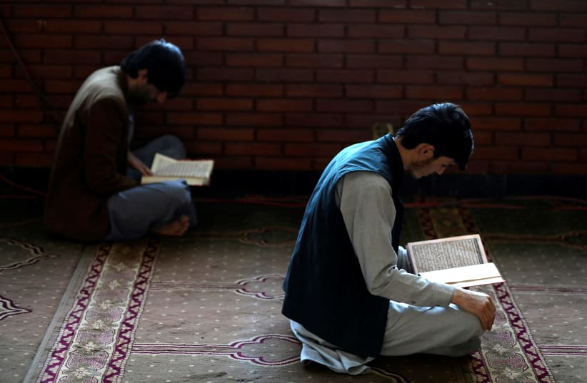  Afghan men read the Koran at a mosque during the holy month of Ramadan in Kabul, Afghanistan, April 5, 2022. (photo credit:  REUTERS/ALI KHARA)