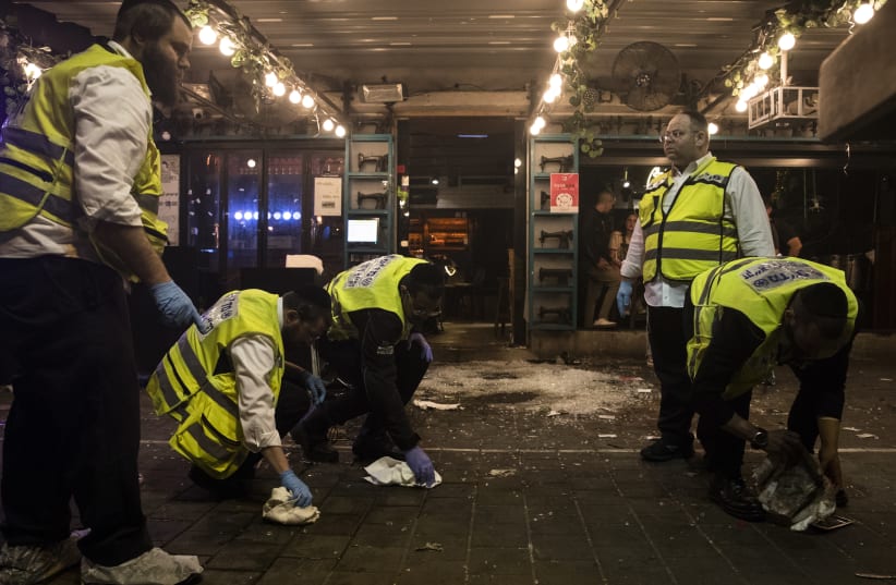  Members of Israeli ZAKA team clean blood from the site after a shooting terror attack on Dizengoff street on April 8, 2022 in Tel Aviv (photo credit: Amir Levy/Getty Images)