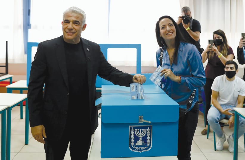  Yair and Lihi Lapid cast their ballots at a Tel Aviv polling station on March 23, 2021.  (photo credit: CORINNA KERN/REUTERS)