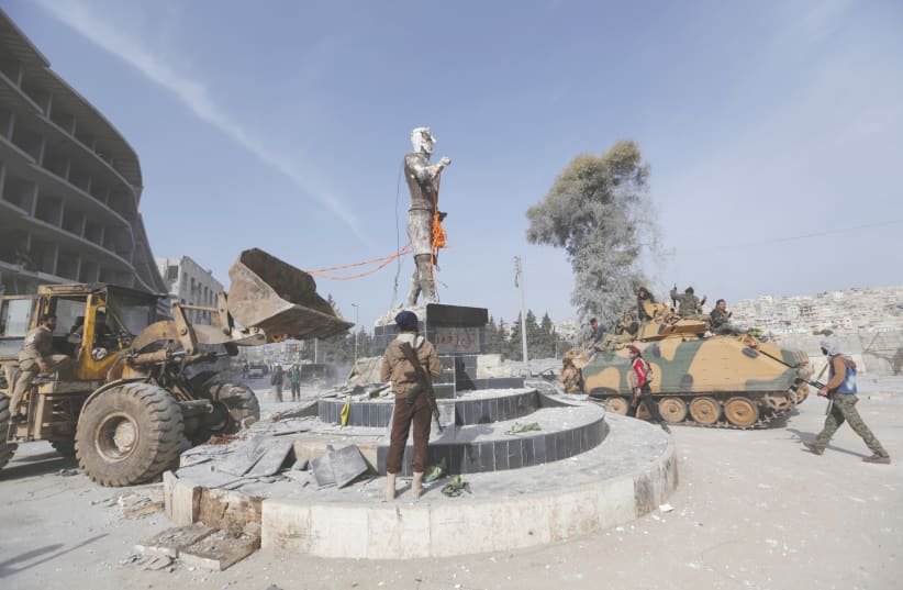 TURKISH-BACKED Free Syrian Army members pull down a Kurdish statue in the center of Afrin, Syria, in 2018. (photo credit: Khalil Ashawi/Reuters)