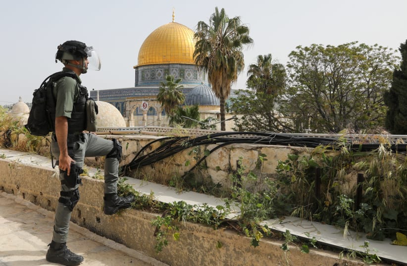 Border Police officer stands in front of the Dome of the Rock, April 18, 2022 (photo credit: MARC ISRAEL SELLEM)