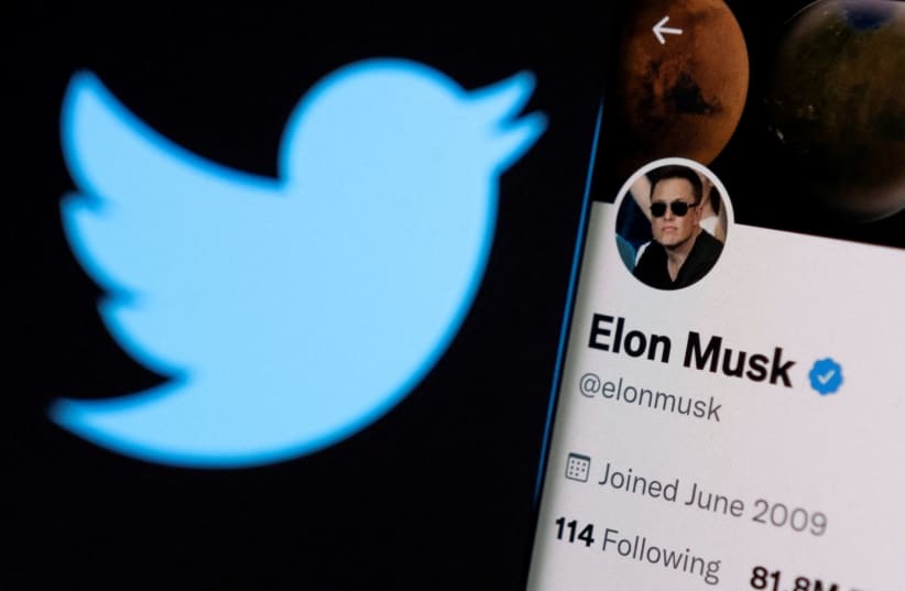 Elon Musk's twitter account is seen on a smartphone in front of the Twitter logo in this photo illustration taken, April 15, 2022. (photo credit: REUTERS/DADO RUVIC/ILLUSTRATION/FILE PHOTO)