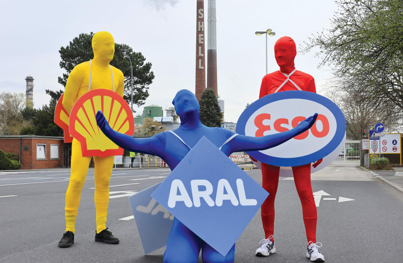  Activists in morph suits protest against Russian energy imports by oil companies Shell, Aral and Esso after the Russian invasion of Ukraine, in front of the Rhineland oil refinery in Cologne, Germany on April 4. (photo credit: Wolfgang Rattay/Reuters)