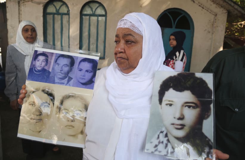  A PALESTINIAN woman holds portraits of relatives she said were killed in the 1982 Sabra and Shatila massacre in Beirut. The book examines whether Irgun and Lehi fighters perpetrated a massacre against Palestinians at Deir Yasin in 1948. (photo credit: AZIZ TAHER/REUTERS)
