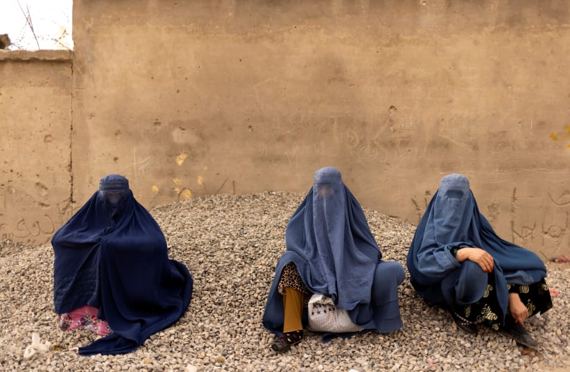  Women wearing burqas pause at the side of a road in Kabul, Afghanistan October 26, 2021. (photo credit: REUTERS/JORGE SILVA)
