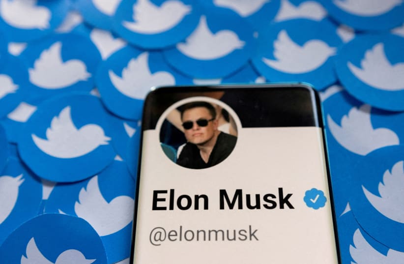  Elon Musk's Twitter profile is seen on a smartphone placed on printed Twitter logos in this picture illustration taken April 28, 2022 (photo credit: REUTERS/DADO RUVIC/ILLUSTRATION)
