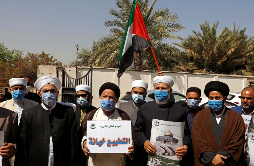 Clerics hold signs and the Palestinian flag during a protest against normalizing ties with Israel, in front of the Palestinian embassy in Baghdad, Iraq September 15, 2020. (photo credit: REUTERS/KHALID AL-MOUSILY)