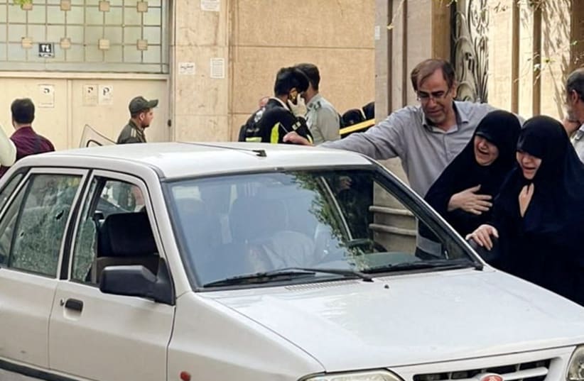  Family members of Colonel Sayad Khodai, a member of Iran's Islamic Revolution Guards Corps, weep over his body in his car after he was reportedly shot by two assailants in Tehran, Iran, May 22, 2022. (photo credit: IRGC/WANA (West Asia News Agency)/Handout via REUTERS)