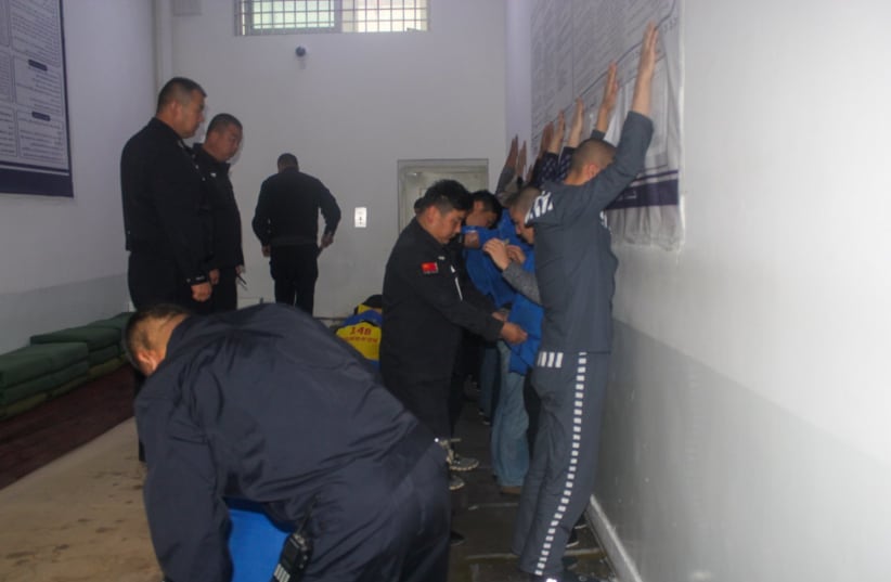  An image taken from the Xinjiang Police Files showing security guards searching prisoners in what researchers presume was a drill  (photo credit: VICTIMS OF COMMUNISM MEMORIAL FOUNDATION)