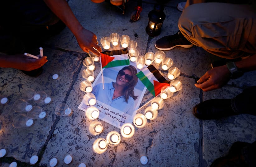  People light candles during a vigil in memory of Al Jazeera journalist Shireen Abu Akleh, who was killed during an Israeli raid, outside the Church of the Nativity in Bethlehem, in the Israeli-occupied West Bank, May 16, 2022 (photo credit: REUTERS/MUSSA QAWASMA)