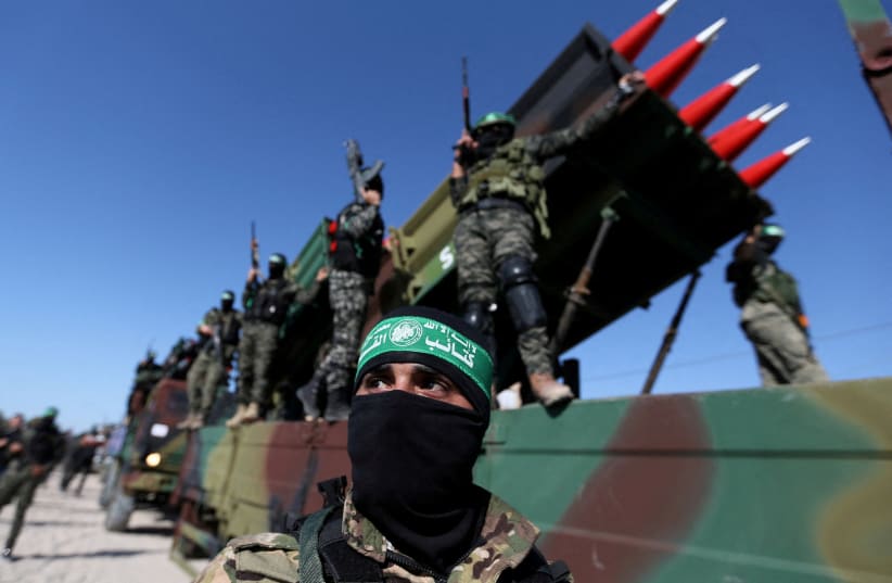 Terroristas palestinos de Hamas asisten a una manifestación contra Israel en Khan Younis, en el sur de la Franja de Gaza, el 27 de mayo de 2021 (crédito de la foto: REUTERS/IBRAHEEM ABU MUSTAFA)