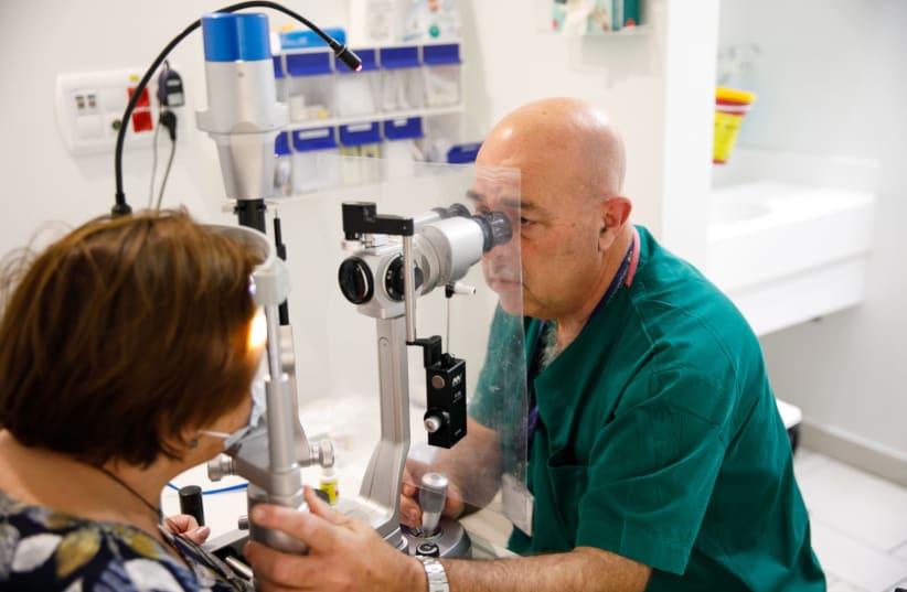  Professor Joseph Pikkel testing a patient's eyesight as part of research on the connction between COVID-19 and sight-impairment (photo credit: COURTESY)