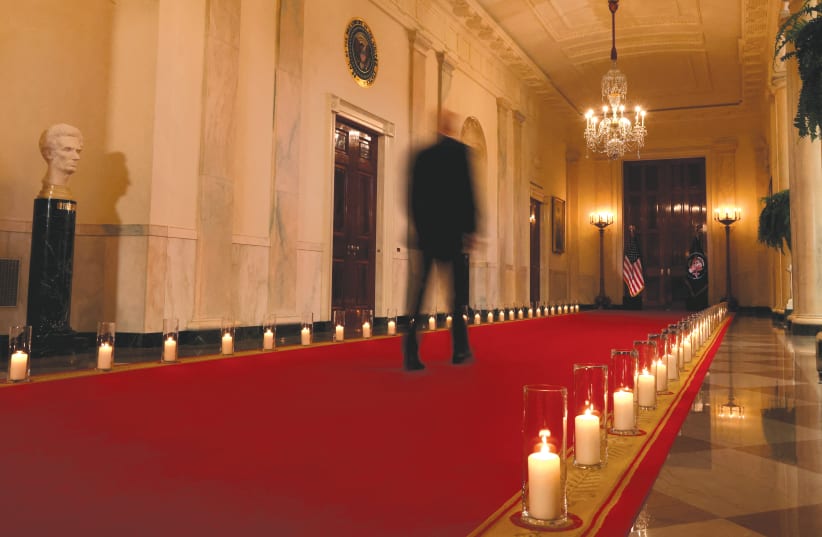  US PRESIDENT Joe Biden (blurred in this slow shutter speed photo) walks down a hallway lined with candles representing victims of gun violence, after he spoke about the issue in an address to the nation from the White House, last Thursday (photo credit: LEAH MILLIS/REUTERS)