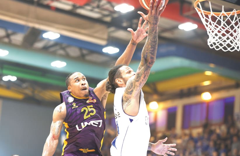  HAPOEL HOLON’S Tyrus McGee (right) goes up to challenge a shot by Bnei Herzliya’s Chris Babb during Holon’s 78-71 road victory in Game 1 of the teams’ best-of-three Israel Winner League final series. McGee scored a game-high 23 points. (photo credit: DANNY MARON)