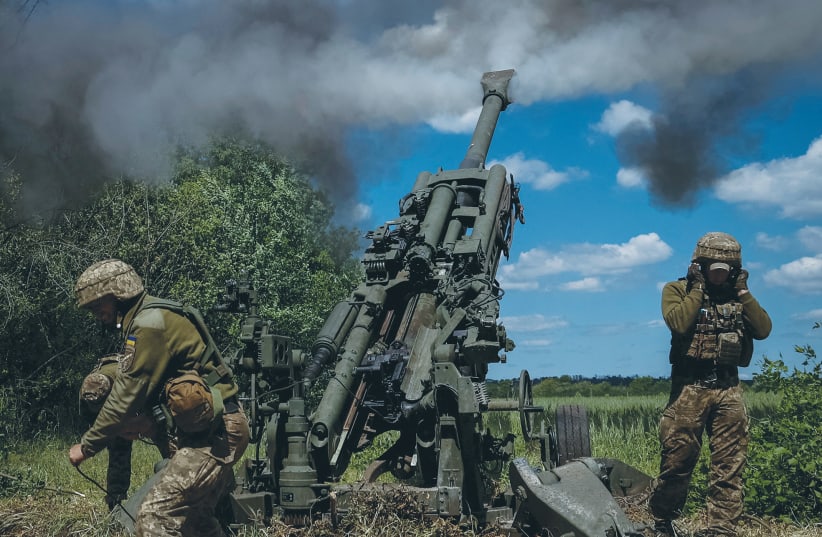  UKRAINIAN SERVICE members fire a shell from an M777 Howitzer near a frontline in Donetsk Region, Ukraine, this past week. (photo credit: REUTERS)