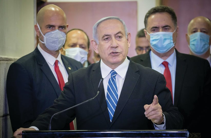  THEN-PRIME Minister Benjamin Netanyahu is surrounded by Likud lawmakers as he gives a press statement ahead of the start of his trial at Jerusalem District Court last year.  (photo credit: YONATAN SINDEL/FLASH90)