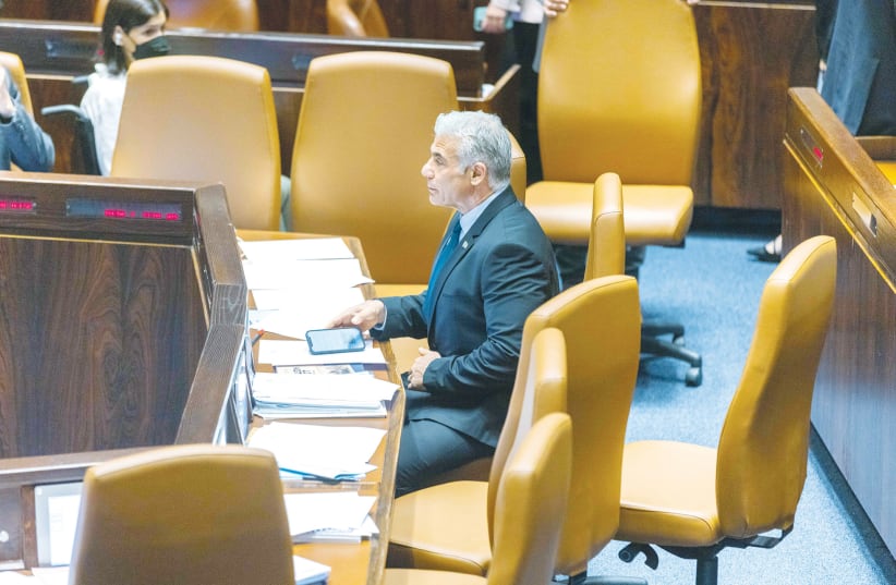  INCOMING PRIME Minister Yair Lapid sits alone after the Knesset convened yesterday to disperse and call a new election.  (photo credit: OLIVIER FITOUSSI/FLASH90)