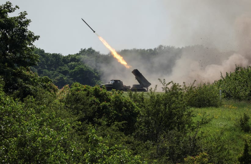 Ukrainian service members fire a BM-21 Grad multiple rocket launch system, near the town of Lysychansk, Luhansk region, amid Russia's attack on Ukraine, June 12, 2022. (photo credit: REUTERS/GLEB GARANICH/FILE PHOTO)