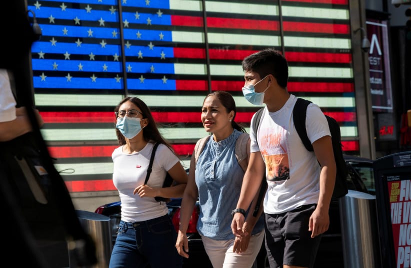  People wear masks around Times Square, as cases of the infectious coronavirus Delta variant continue to rise in New York City, New York, US, July 23, 2021 (photo credit: REUTERS/EDUARDO MUNOZ)