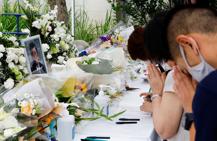  Mourners pray for late former Japanese Prime Minister Shinzo Abe, who was shot while campaigning for a parliamentary election, at Headquarters of the Japanese Liberal Democratic Party in Tokyo, Japan July 12, 2022 (photo credit: REUTERS/KIM KYUNG-HOON)