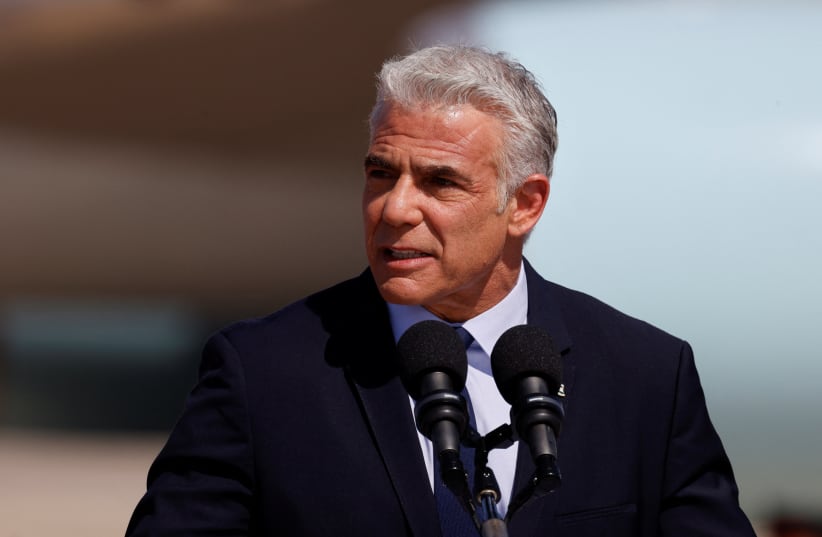 Prime Minister Yair Lapid speaks during a ceremony to welcome US President Joe Biden in Israel, at Ben Gurion International Airport in Lod near Tel Aviv, Israel, July 13, 2022 (photo credit: AMIR COHEN/REUTERS)