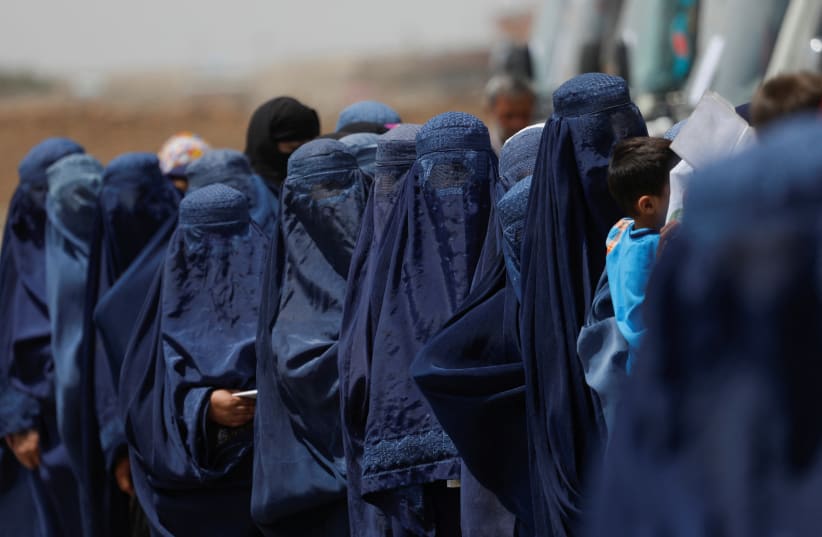  Displaced Afghan women stand waiting to receive cash aid for displaced people in Kabul, Afghanistan, July 28, 2022. (photo credit:  REUTERS/ALI KHARA)