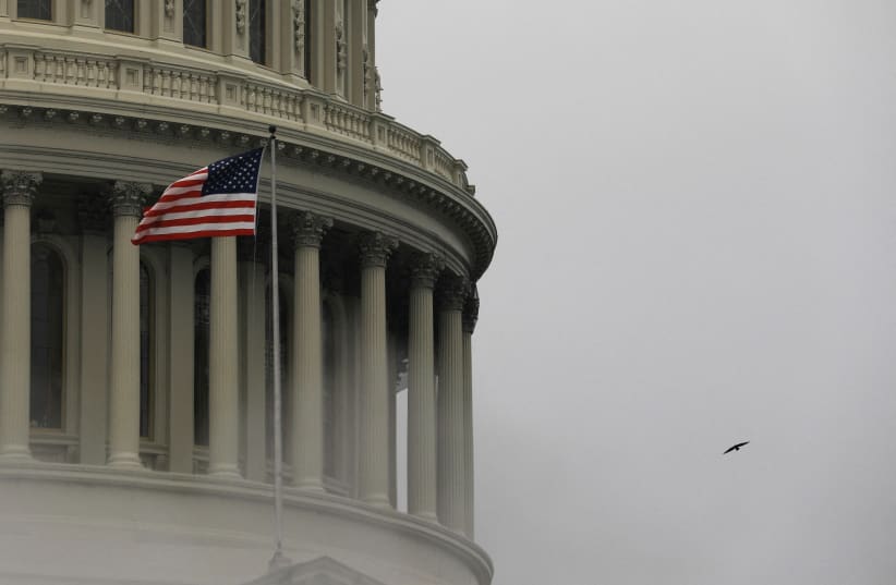 A bird flies by the United States Capitol building in Washington, US, March 17, 2022.   (photo credit: REUTERS/Emily Elconin/File Photo)