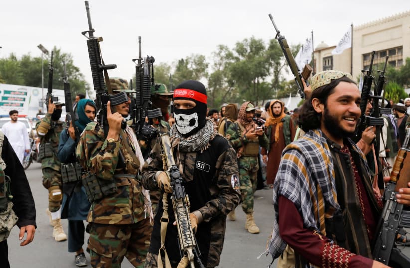  Taliban fighters celebrate the first anniversary of the fall of Kabul on a street in Kabul, Afghanistan, August 15, 2022.  (photo credit:  REUTERS/ALI KHARA)