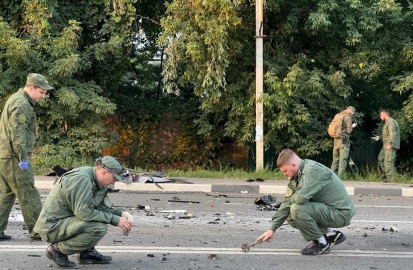  Investigators work at the site of a suspected car bomb attack that killed Darya Dugina, daughter of ultra-nationalist Russian ideologue Alexander Dugin, in the Moscow region, Russia August 21, 2022. (photo credit: Investigative Committee of Russia/Handout via REUTERS)