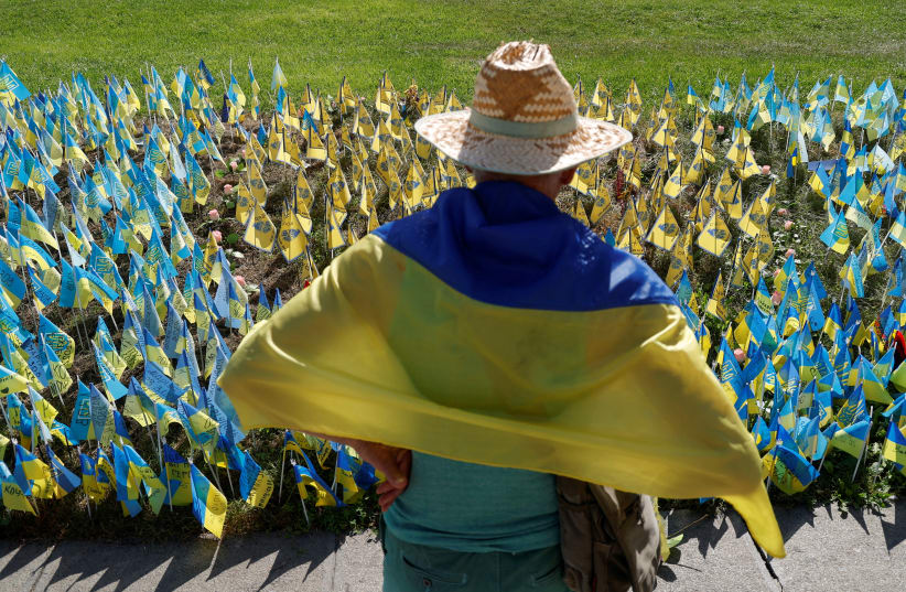  A man stands next to Ukrainian flags with names of service members, who are in Russian captivity, as Russia's attack on Ukraine continues, at the Independence square in Kyiv, Ukraine August 24, 2022.  (photo credit: REUTERS/VALENTYN OGIRENKO)