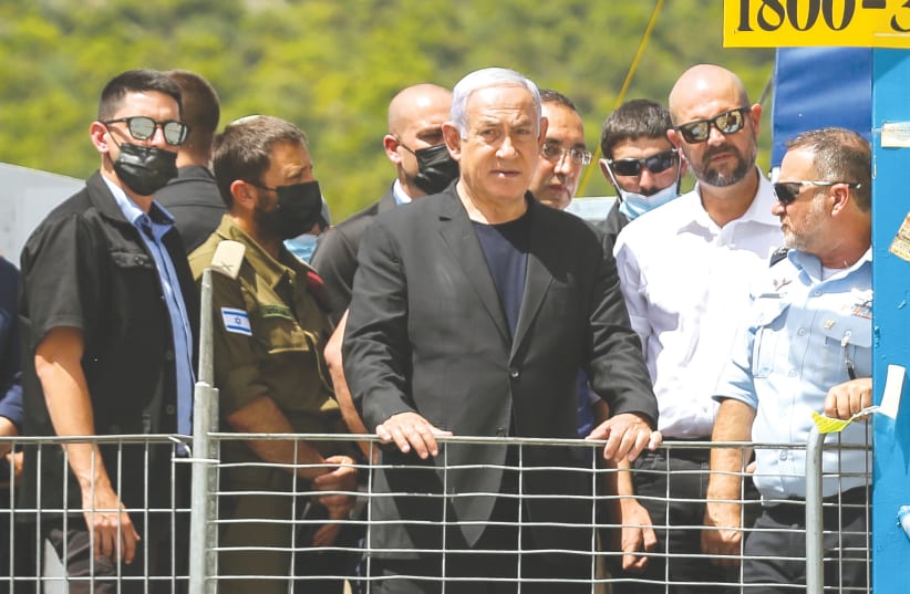  THEN-PRIME MINISTER Benjamin Netanyahu stands to the right of then-internal security minister Amir Ohana and Police Chief Insp.-Gen. Kobi Shabtai, during their visit to the scene of the tragedy at Mount Meron last year.  (photo credit: David Cohen/Flash90)