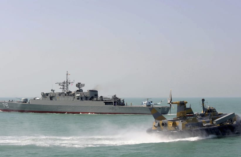 A hovercraft passes by Iran's first domestically made destroyer Jamaran on the southern shores of Iran in the Persian Gulf during inauguration maneuvers, February 21, 2010. (photo credit: REUTERS/EBRAHIM NOROOZI)